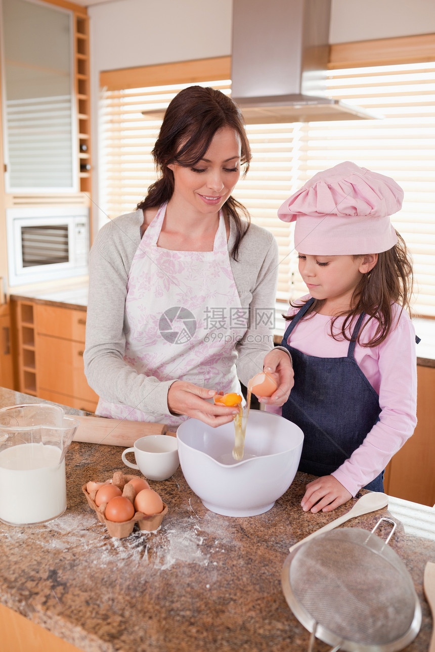一个快乐的母亲和女儿做烘烤的肖像图片