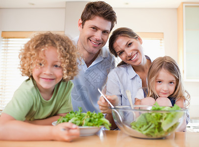 一起准备沙拉的微笑家庭父亲团结厨房中年人孩子儿子幸福女儿男生男人健康高清图片素材