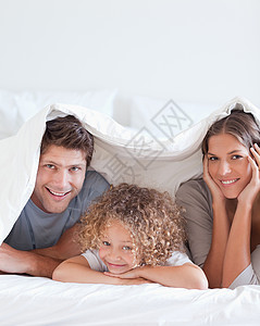 躺在床上的微笑的家庭毯子快乐孩子混血卧室喜悦被单童年母亲男生涵盖高清图片素材