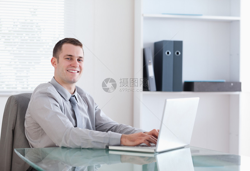 在笔记本电脑上工作的满意商务人士图片
