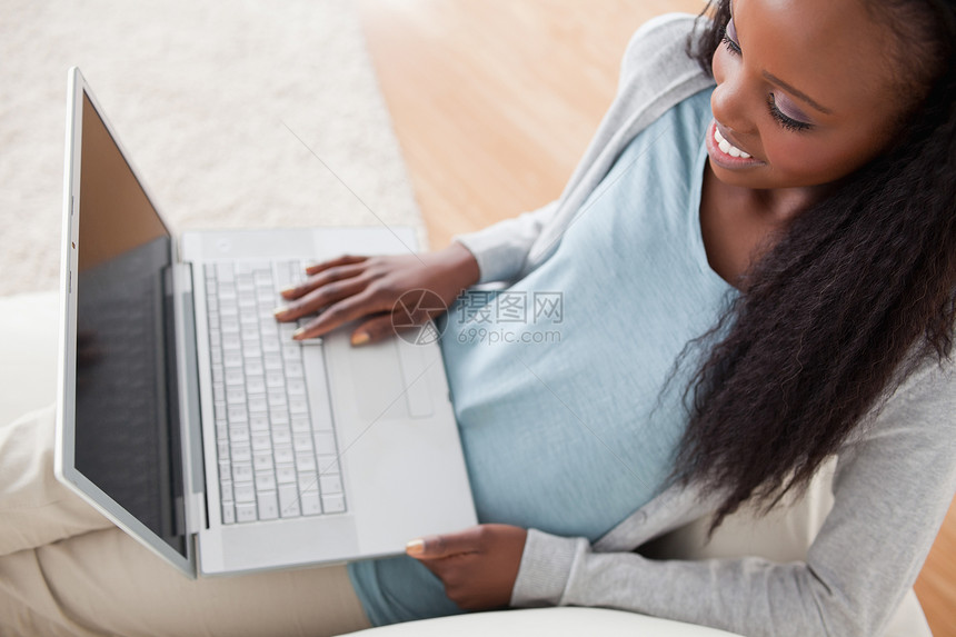 女人用笔记本在沙发上客厅网络女性电脑微笑互联网技术长椅图片