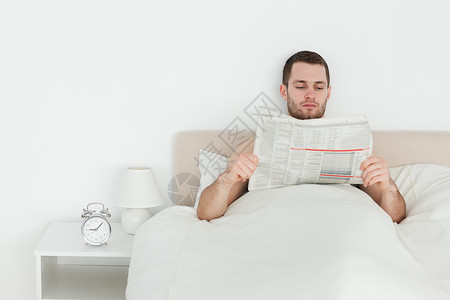 男人看报纸微笑房间外表商业床单阅读闲暇乐趣年轻人卧室坐着高清图片素材