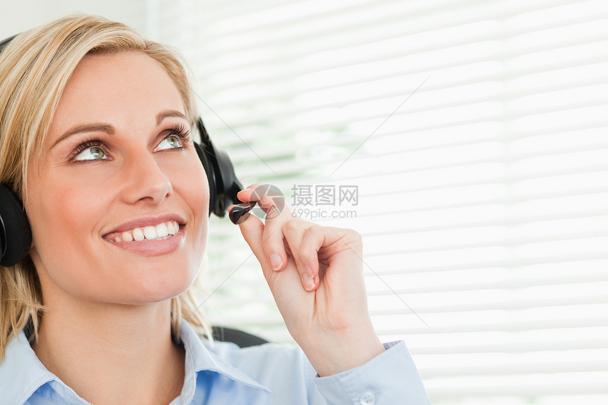 手戴耳盔的微笑女商务人士中心帮助销售量操作员耳机电话服务商务麦克风女性图片