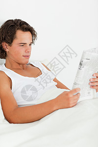 男人看报纸的肖像头发商务人士阳光乐趣年轻人商业房间卧室享受说谎高清图片素材