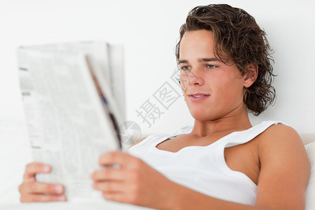 一位年轻人在看报纸时的近身商业高清图片素材