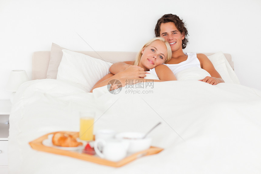一对一对微笑的夫妇 把早餐放在盘子上图片