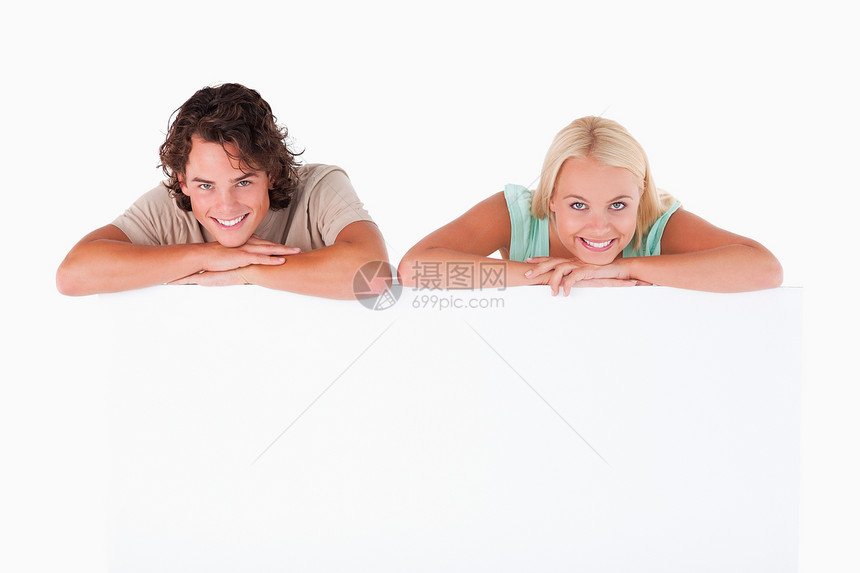 微笑的情侣靠在白板上图片