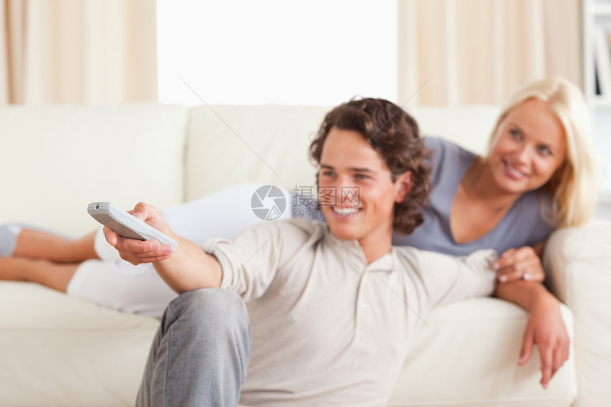 在看电视的年轻夫妇中微笑图片