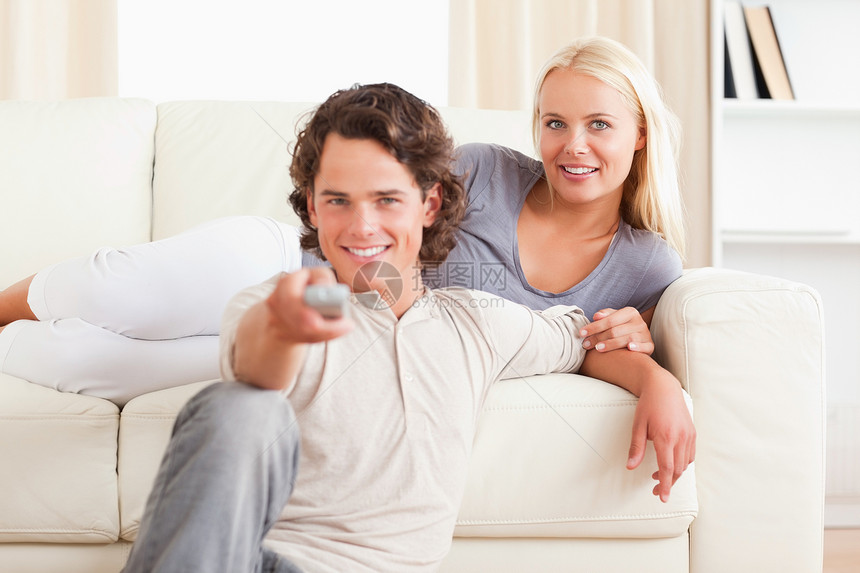 可爱的一对在看电视的情侣交换电视夫妻年轻人娱乐手表幸福乐趣闲暇频道图片