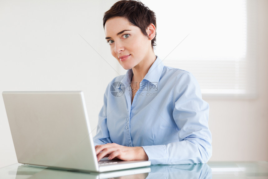 带笔记本电脑的迷人女商务人士图片