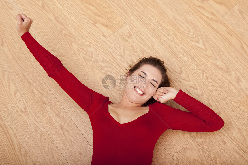 快乐的女人躺在地上乐趣生活休息黑发微笑地面女性红色成人享受图片
