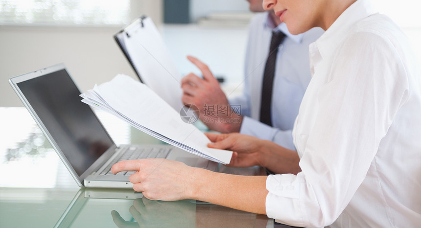 办公室工作人员从蓝图文件中打入一份报告的办公室工作人员键盘商务年轻人笔记本商业伙伴生意人桌面电脑技术图片