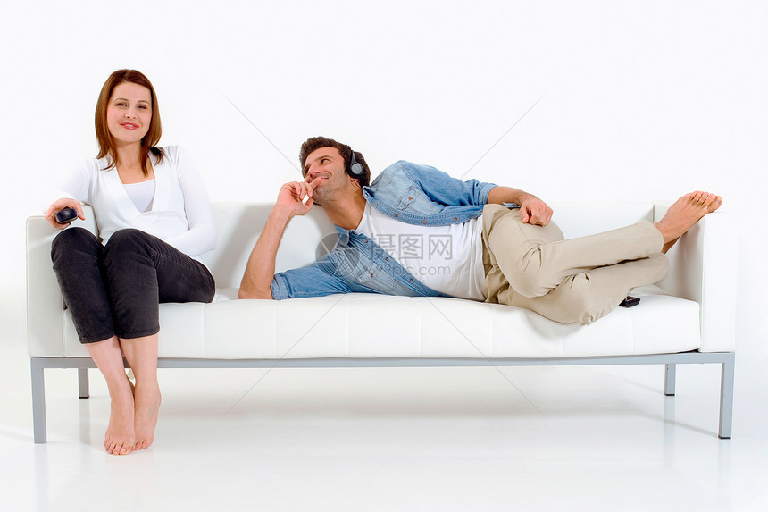 在沙发上看电视的分居夫妇夫妻日常生活耳机牛仔裤说谎两个人客厅异性恋女士异性图片