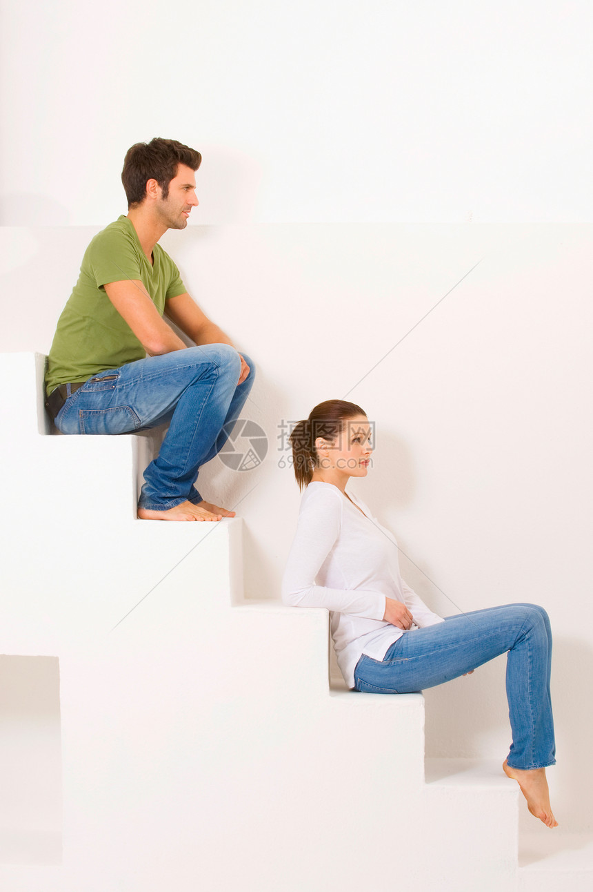 坐在台阶上的一对夫妇两人异性恋牛仔裤夫妻休闲装成年人异性男人女士日常生活图片