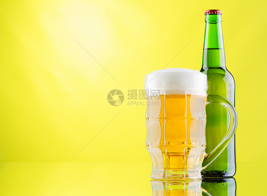 黄色背景的啤酒杯和酒瓶啤酒绿色白色金子瓶子反射气泡玻璃草稿泡沫图片