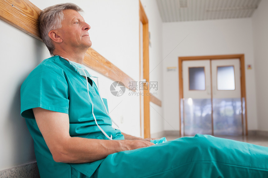疲劳外科医生坐在医院走廊的地板上图片