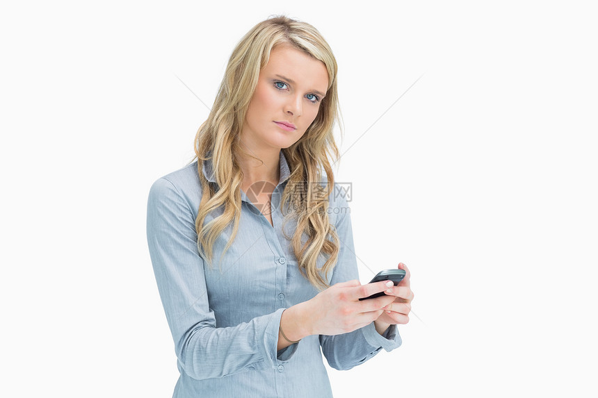 金发女人在她的智能手机上发短信图片