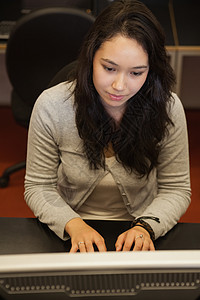 集中关注坐在电脑上的妇女学生高清图片素材