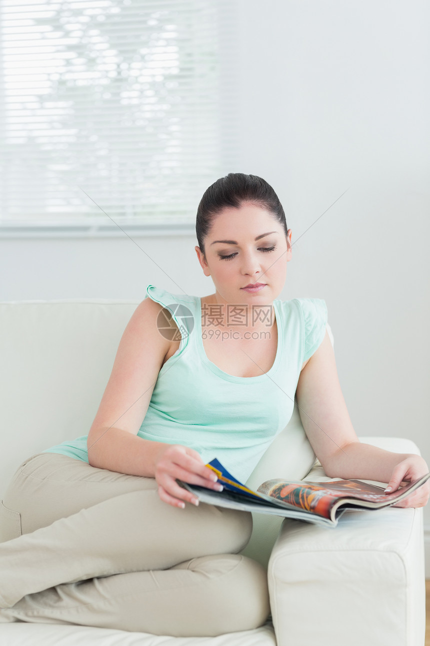 坐在沙发上看书的女人窗户长椅公寓头发百叶窗杂志房子女性休息室棕色图片