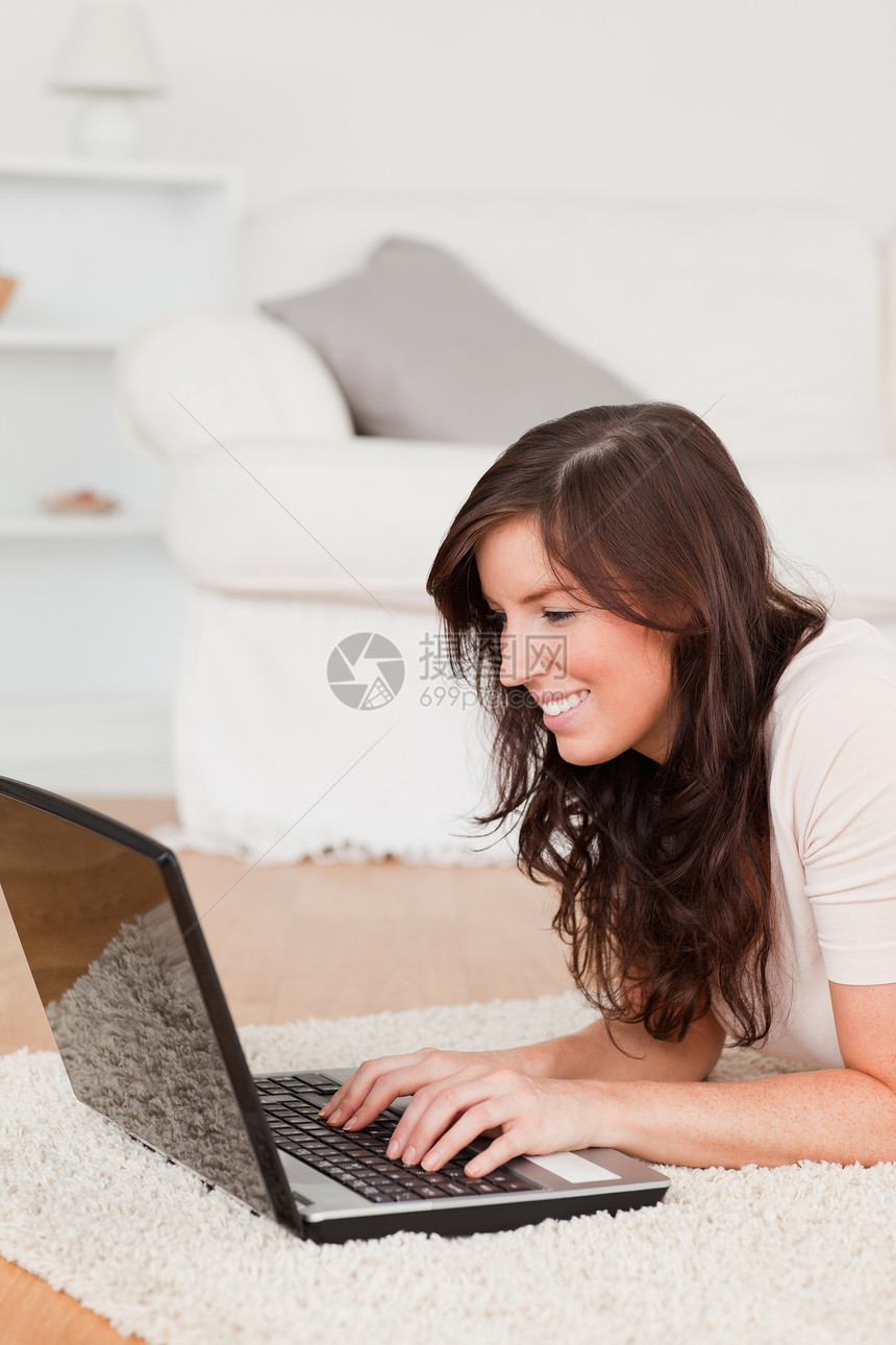 好漂亮的黑发美女 躺在床上时用笔记本电脑放松图片