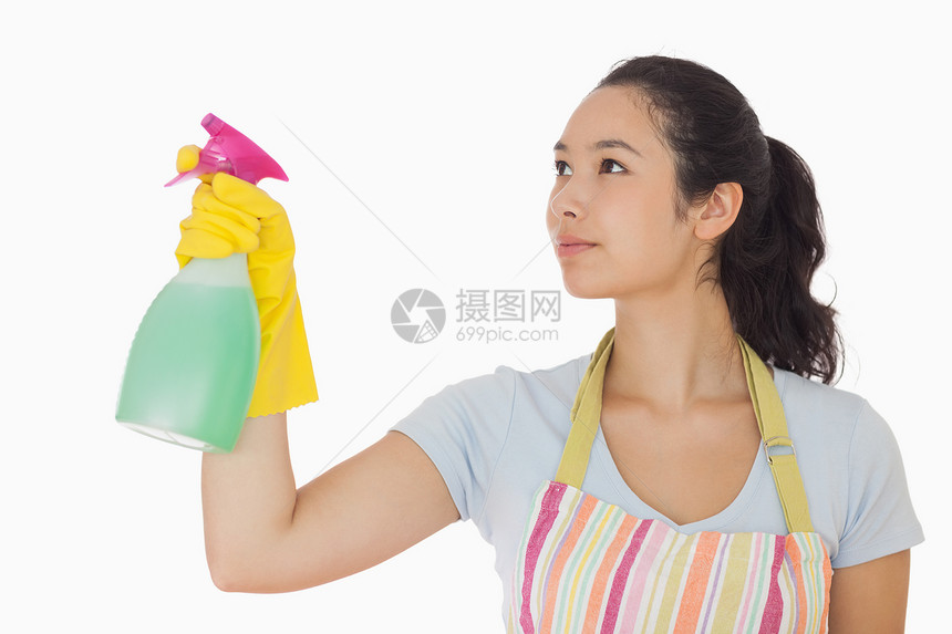 年轻妇女喷洒清洁剂图片