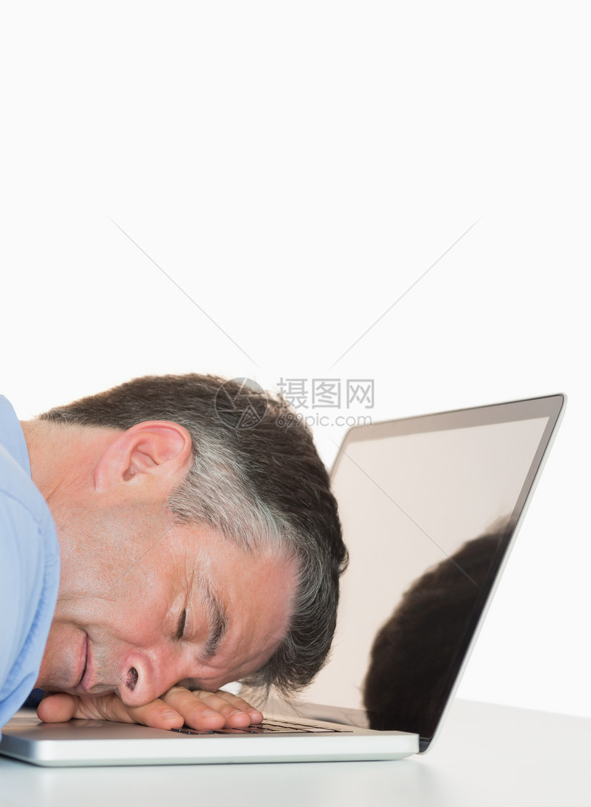 疲惫的人睡在笔记本电脑上图片