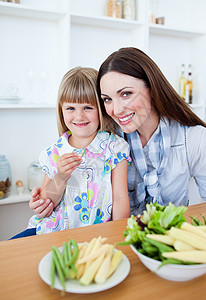 和妈妈一起吃蔬菜的快乐小女孩啊!关爱高清图片素材