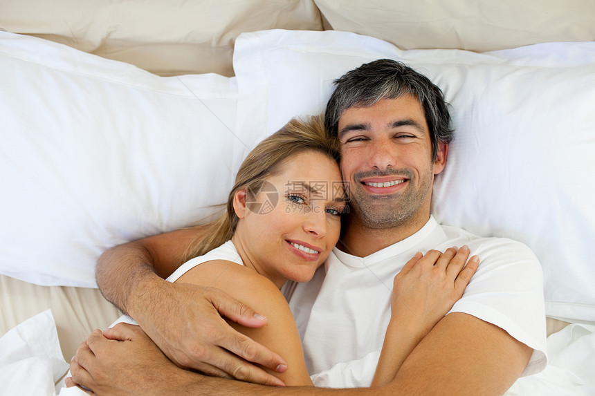 微笑的情侣躺在床上图片