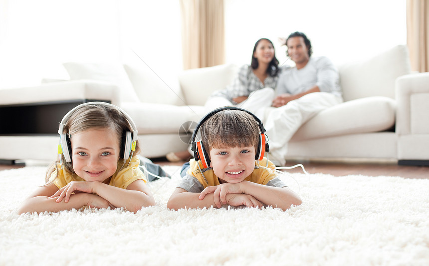 用耳机监听音乐的可爱兄弟姐妹快乐团体幸福父母儿子孩子男生母亲歌曲微笑图片