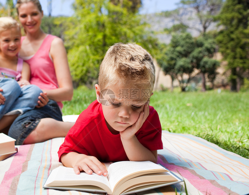 和家人一起野餐时看书的时候读书的男孩图片