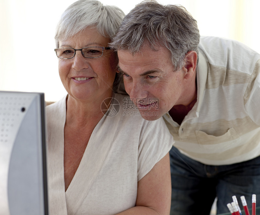 在家使用计算机的老年夫妇肖像;图片