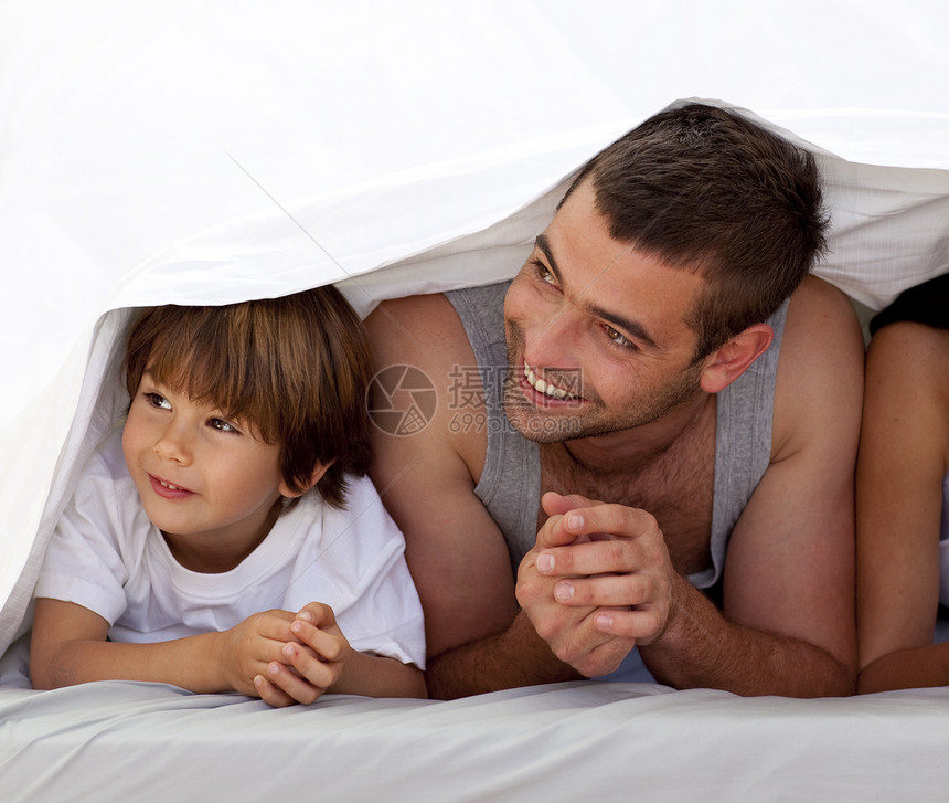 父亲和儿子在床单下微笑图片