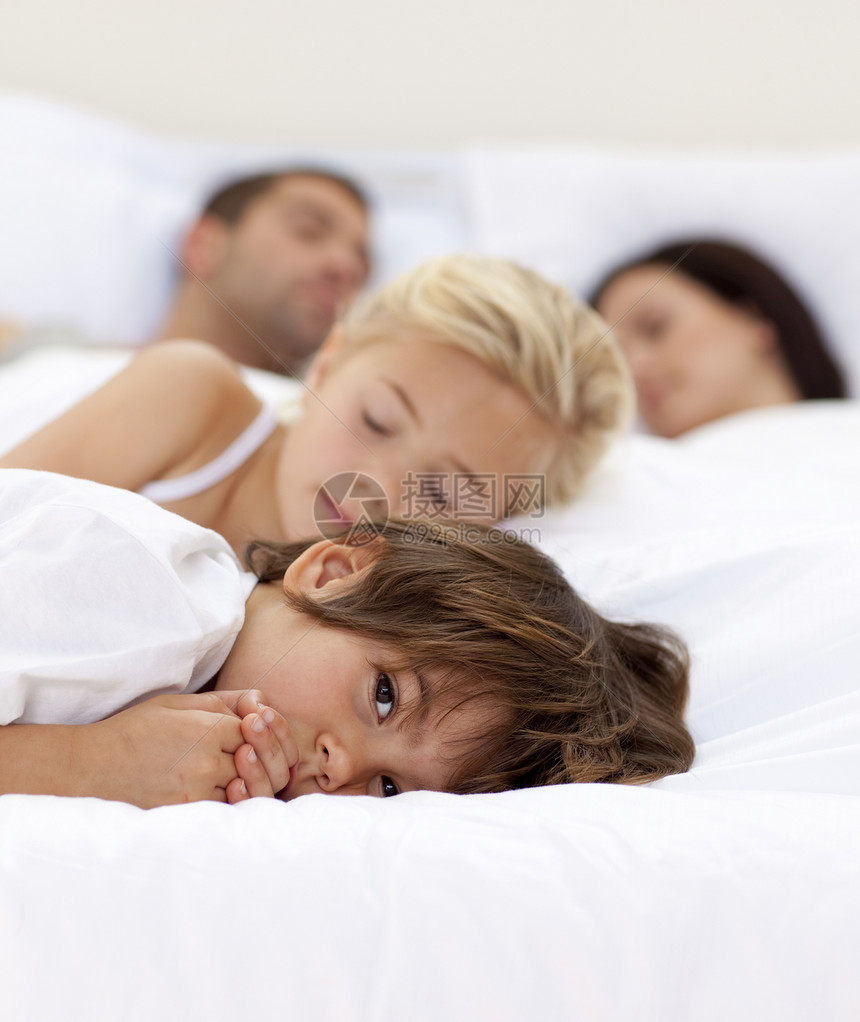 小男孩与父母和姐姐睡着时 放松了一下图片
