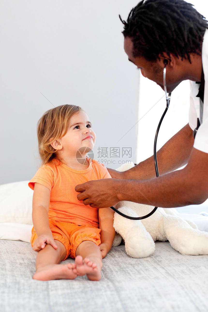 在医院检查一个小女孩的 自信的医生图片