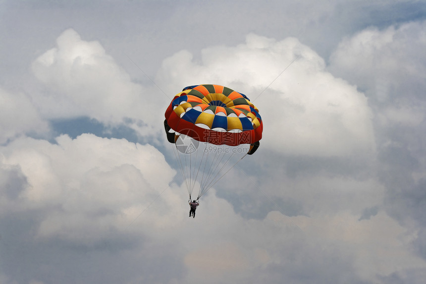 蓝色天空和云层中的男性滑翔伞图片