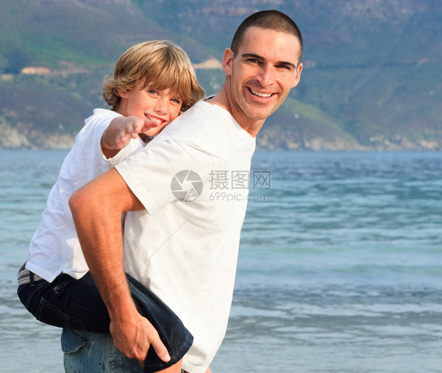 父亲在海滩上载着儿子骑马蓝色孩子男性父母爸爸男人天空成人肩膀家庭图片