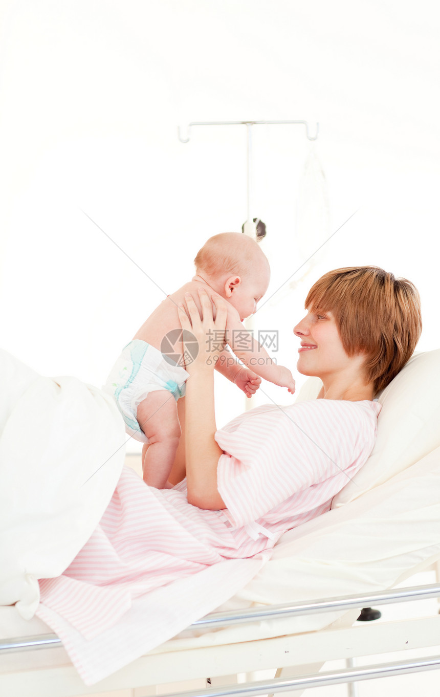 母亲与她儿子玩耍女性房间喜悦父母孩子护士女士青年医院新生图片