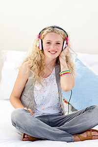 微笑的少女 听音乐的少年女孩手柄耳机音乐娱乐青少年家庭技术大学房间舞蹈背景图片