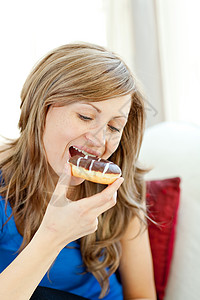 沙圈Radiant女人在沙发上吃甜甜圈背景