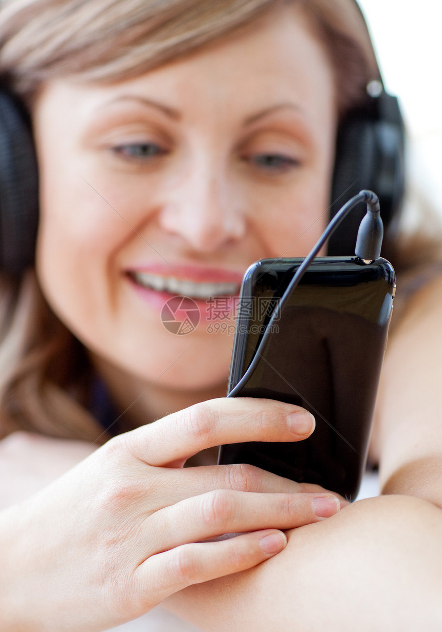 一位快乐的女士用耳机听音乐的肖像图片