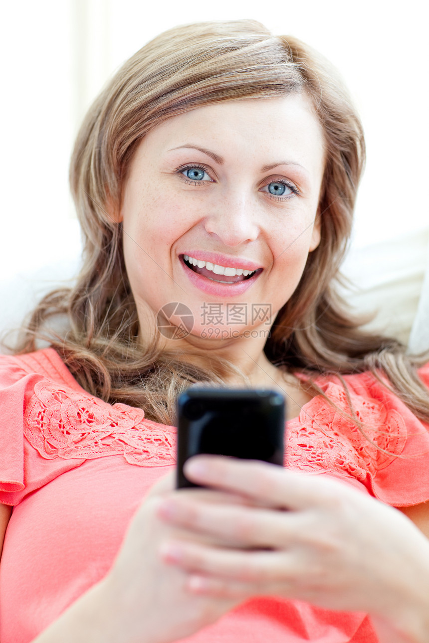 Radiant女士在沙发上发短信长椅女性快乐电子邮件房间客厅说谎成人幸福微笑图片
