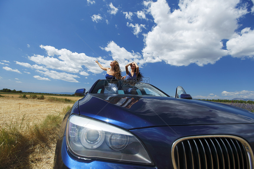 妇女在汽车中跳舞男生天空微笑乐趣蓝色假期友谊玻璃女孩舞蹈图片
