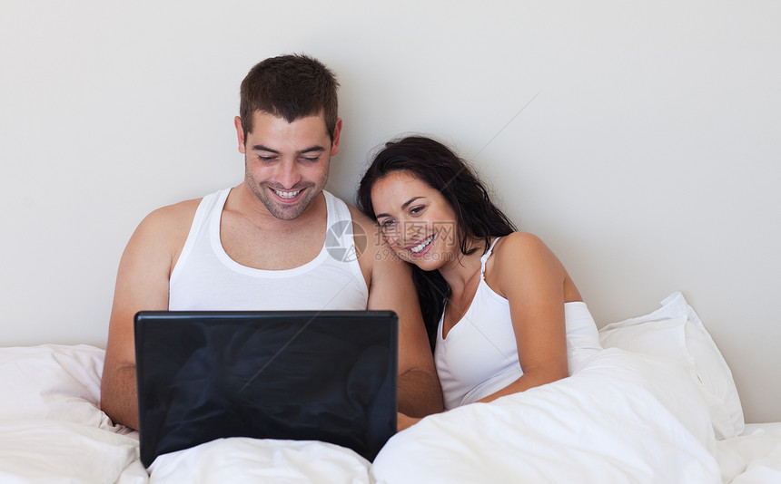 丈夫和妻子使用笔记本电脑网络男人工作互联网女性卧室技术男性休息男朋友图片