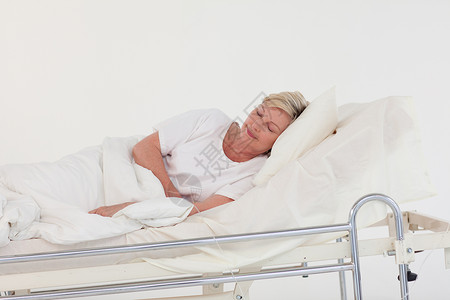 躺在医院床上的老年病妇女药品成人头发女士说谎老年食物眼睛疾病房间背景图片