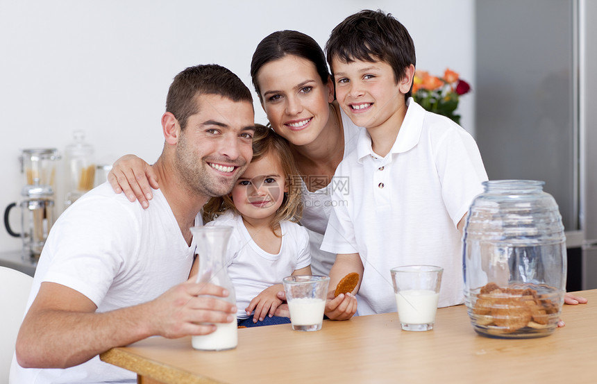 幸福的一家人吃饼干 喝牛奶果汁女儿乐趣母亲男人房子厨房早餐享受水果图片