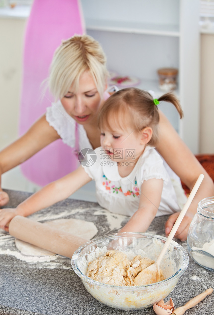 集中的女人与女儿一起烘烤图片