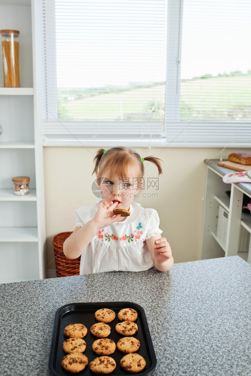坐在饼干前的可爱女孩图片