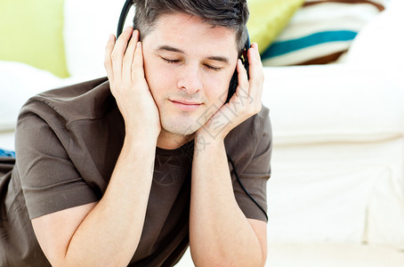 放松的男子听音乐 躺在地板上背景图片