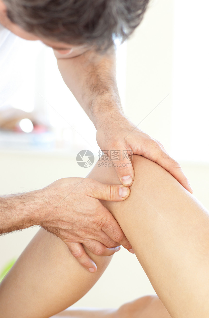 一名年轻理疗师在腿部按摩时的图片
