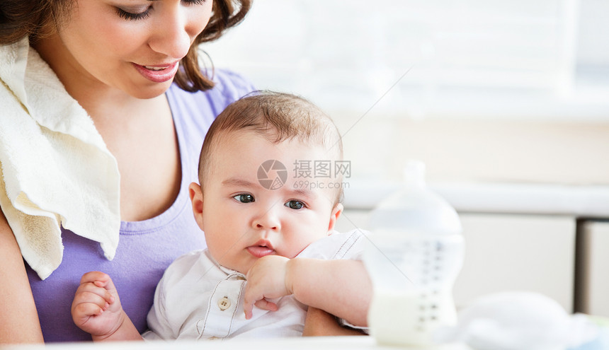 一位迷人的母亲照顾她可爱宝宝的肖像 i图片